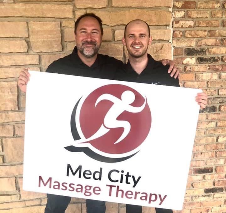 Med City Massage staff holding new signage